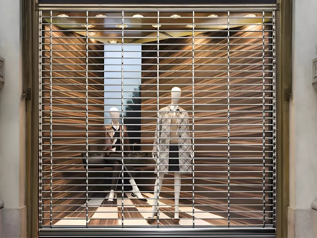 Grille métallique à enroulement devant une vitrine
