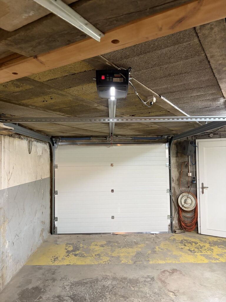 Porte de garage blanche avec moteur au plafond